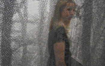 A woman behind a net installation.