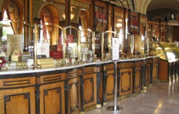 Old fashioned wooden cabinets and mirrored walls of a Budapest cafe.