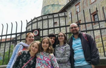 family smiling in front of medieval castle