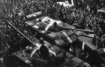 black and white image of tank moving through crowd of people