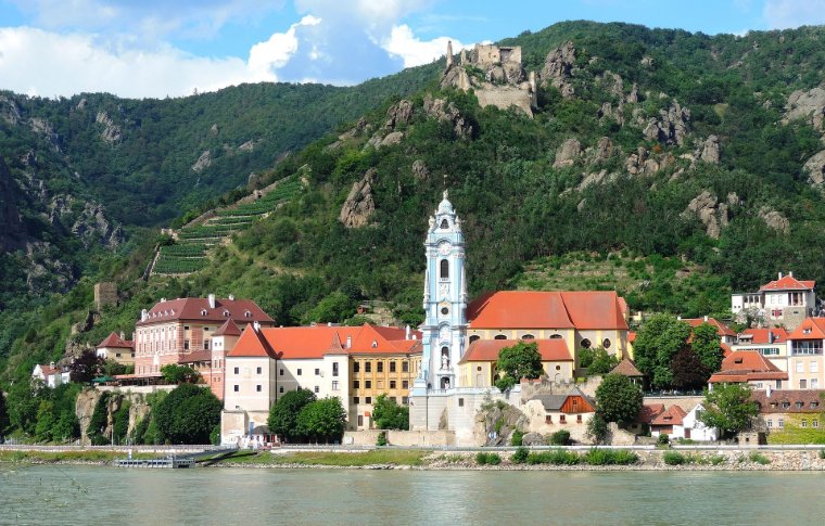 small town with tall white church steeple in front of mountains