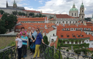 group of people smiling in front of view of red rooftops