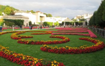 large curated garden with red and yellow flowers in semi circle layout