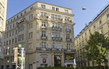 A square topped building in Vienna against a blue sky