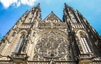 upward view of 2 church steeples and elaborate circle window