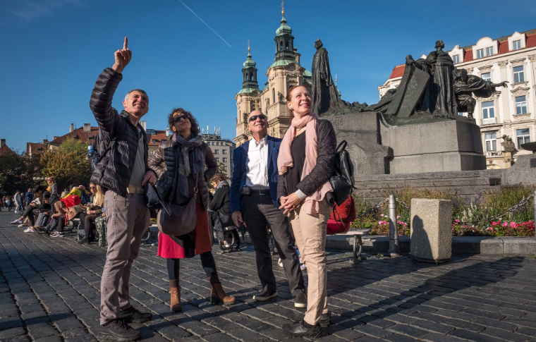 tour guides pointing at object behind camera and smiling