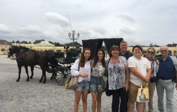 group of people smiling in front of horse and carriage