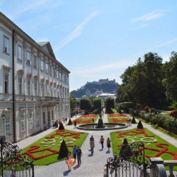 People walking in a garden with a fountain in the center