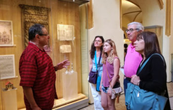 tour guide explaining old documents to group in museum