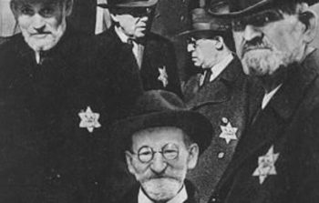 old black and white photo of men with star of david inscribed on their black coats