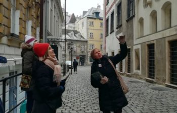 tour guide pointing up and explaning something on cobbled street