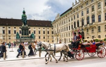 horse and carriage riding past palace in snow