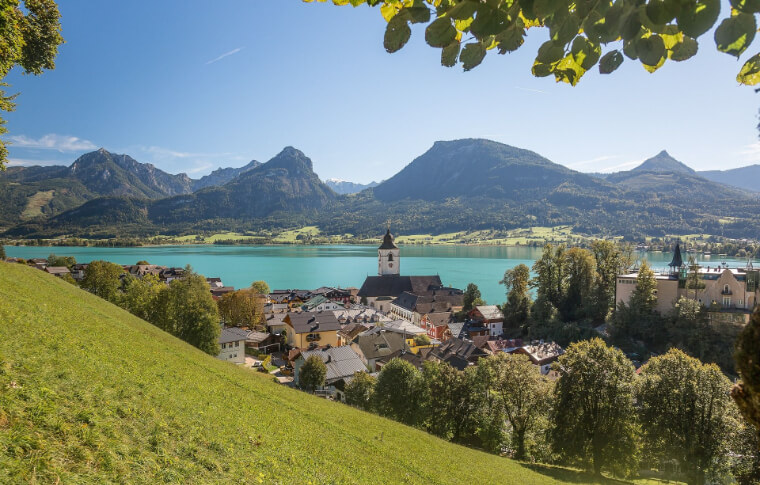 town in the distance next to lake and mountains