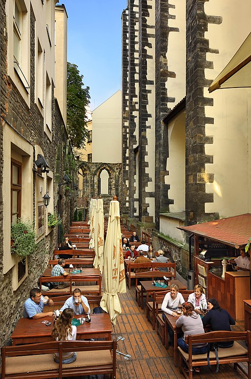 a pub courtyard with people sitting at tables on a sunny day