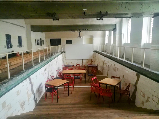 an empty swimming pool with tables and chairs